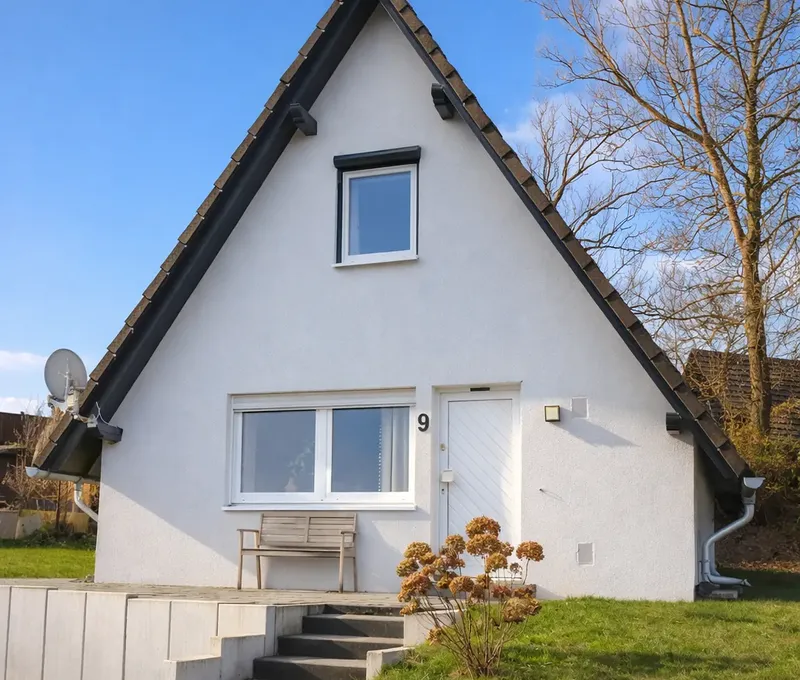 Außenansicht vom Ferienhaus Seeblick mit Eingangstreppe, Terrasse und Garten.