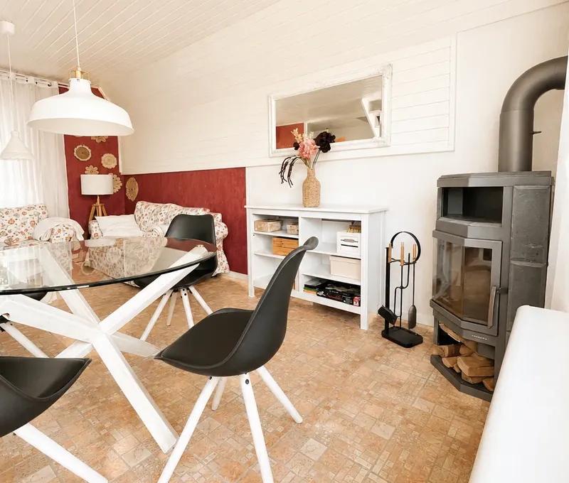 Wohnzimmer im Haus am See mit Kaminofen, Essbereich und Sofa.