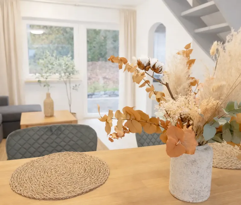 Wohn- und Essbereich im Ferienhaus Seeblick mit Sofa, Esstisch und Dekoration.
