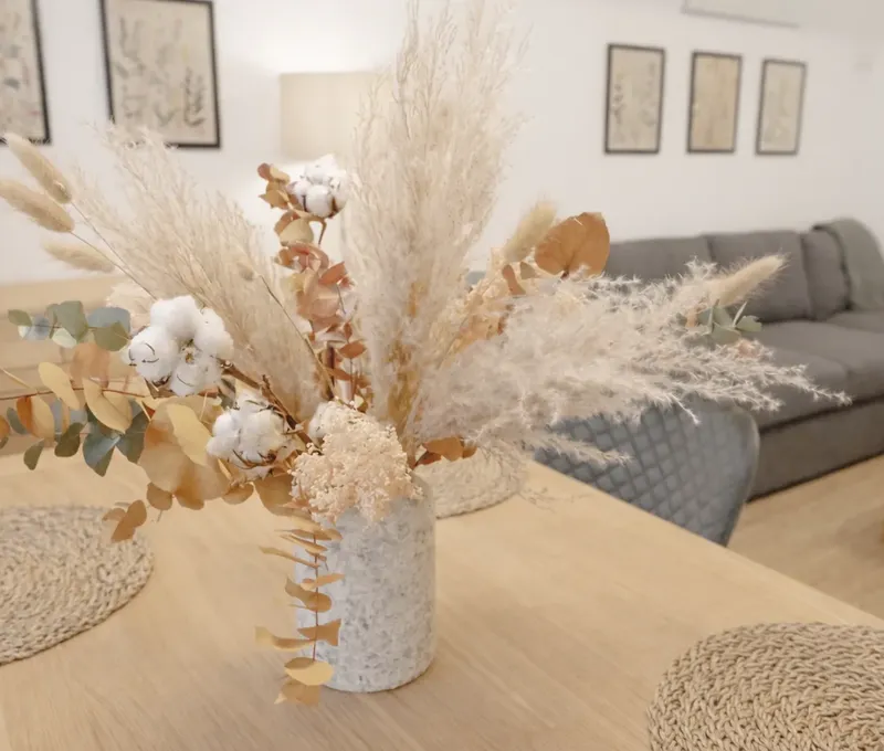 Wohn- und Essbereich im Ferienhaus Seeblick mit Holztisch, Dekoration und Sofa.