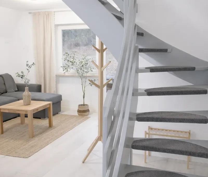 Blick auf Treppe und Wohnbereich im Ferienhaus Seeblick mit heller Einrichtung.