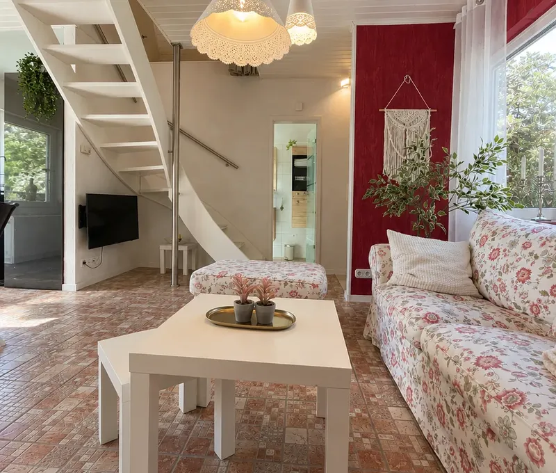 Wohnzimmer im Haus am See mit Sofa, Couchtisch und Blick zum Essbereich.