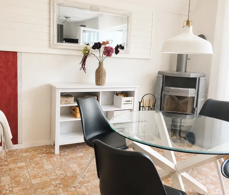 Essbereich im Haus am See mit Glastisch, Stuehlen und Spiegel.