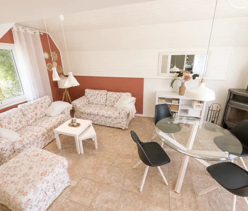 Wohnzimmer im Haus am See mit grosser Sofalandschaft, Couchtisch und hellen Fenstern.