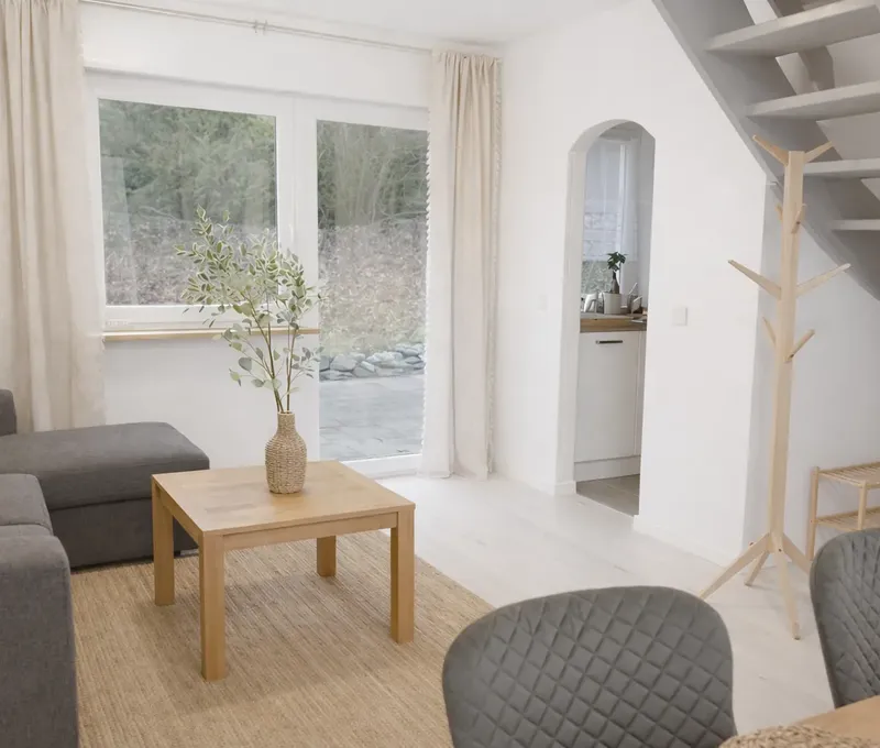Heller Wohnbereich im Ferienhaus Seeblick mit Sofa, Couchtisch und Treppe ins Obergeschoss.